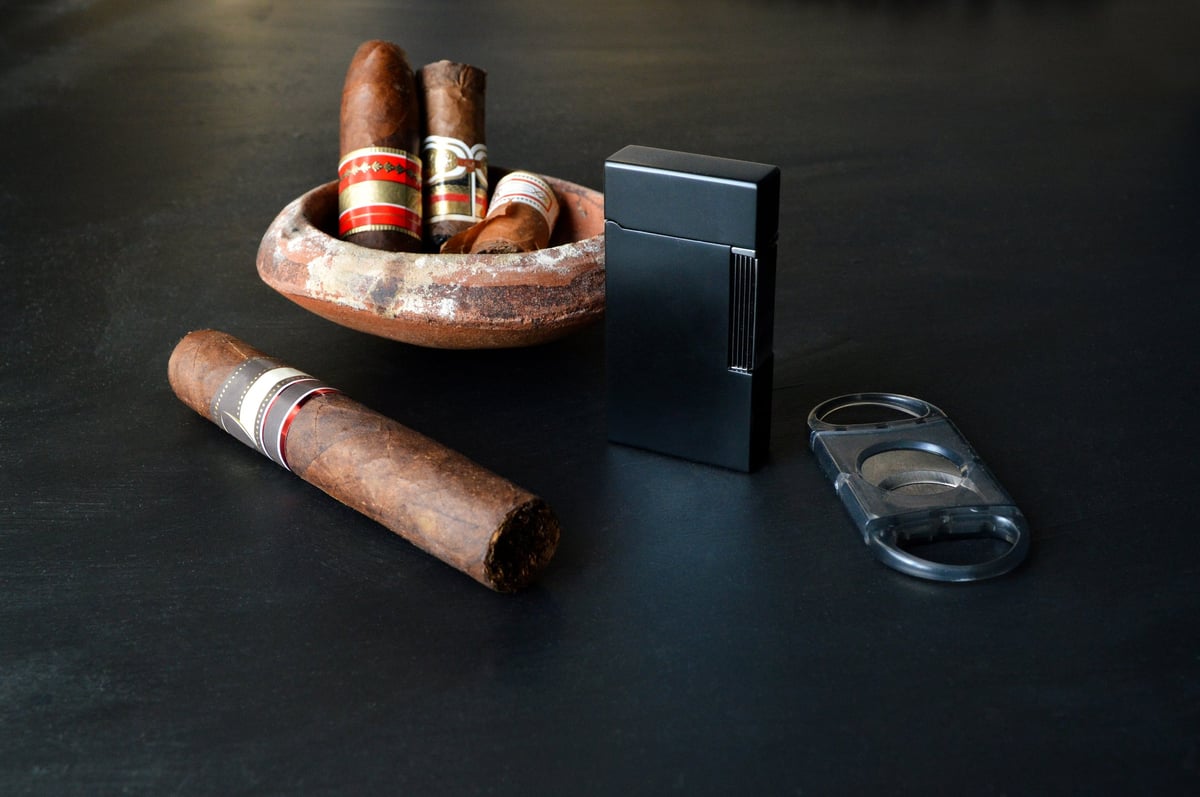 Cigar with a blowtorch lighter and cutter